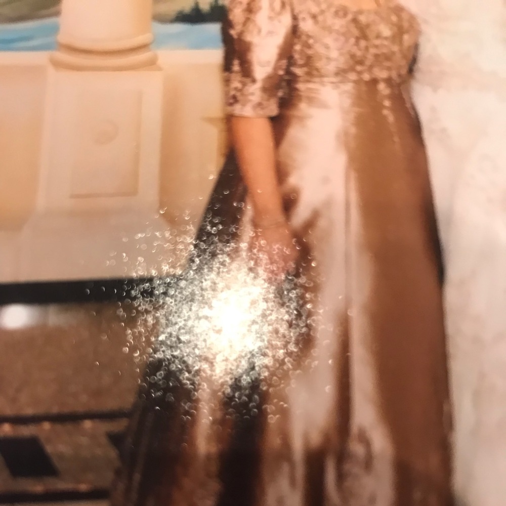 Sequence on top sleeves and button of gown .